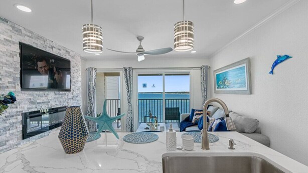 A modern kitchen with a large island, a built-in TV, and a view of the ocean. - Sunset Paradise - Find yourself in Tampa (Tampa)