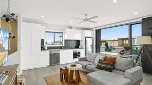 Un appartement moderne comprenant une cuisine, un coin repas et un salon.