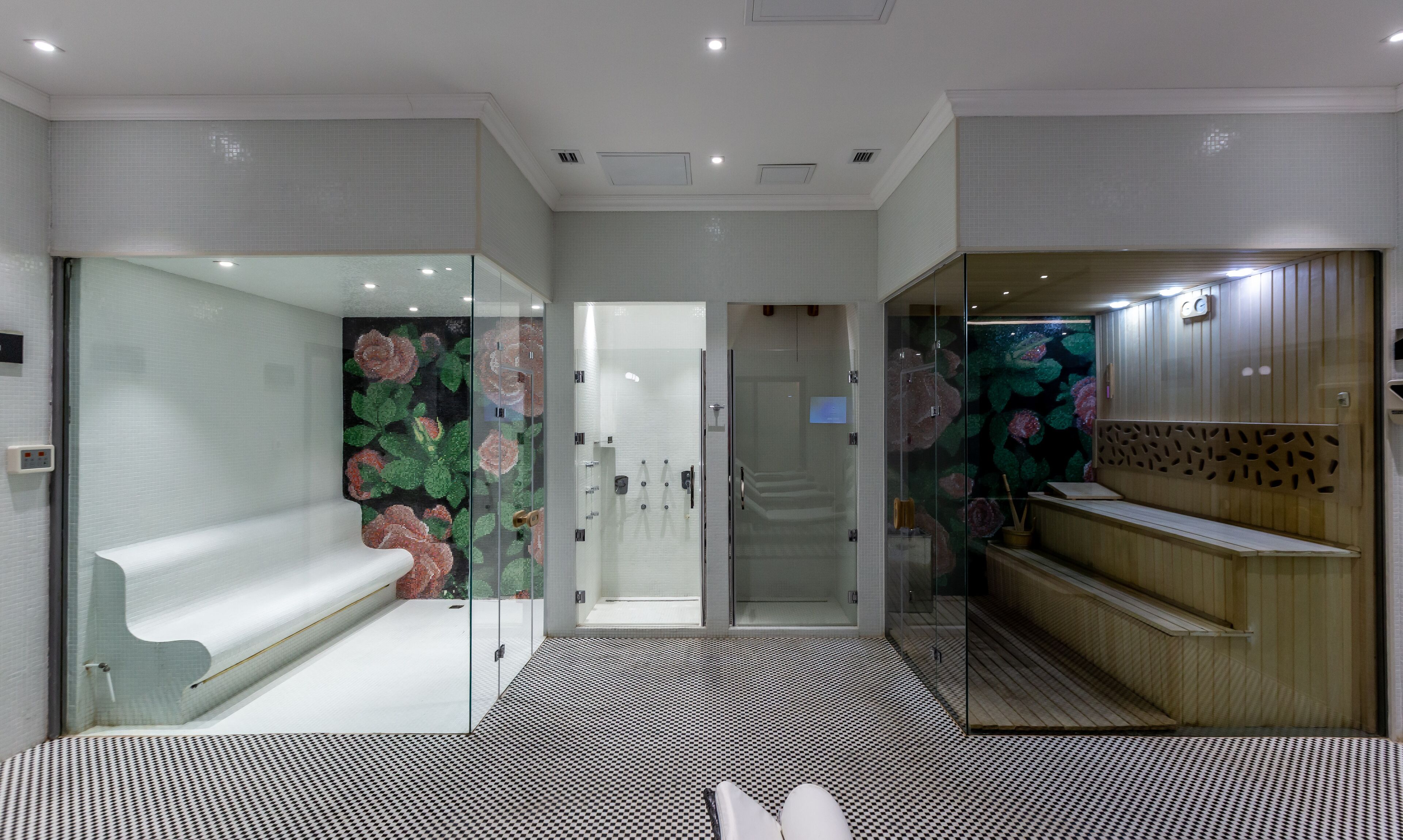 Un bagno moderno con box doccia in vetro, una reception in legno e un pavimento decorato.