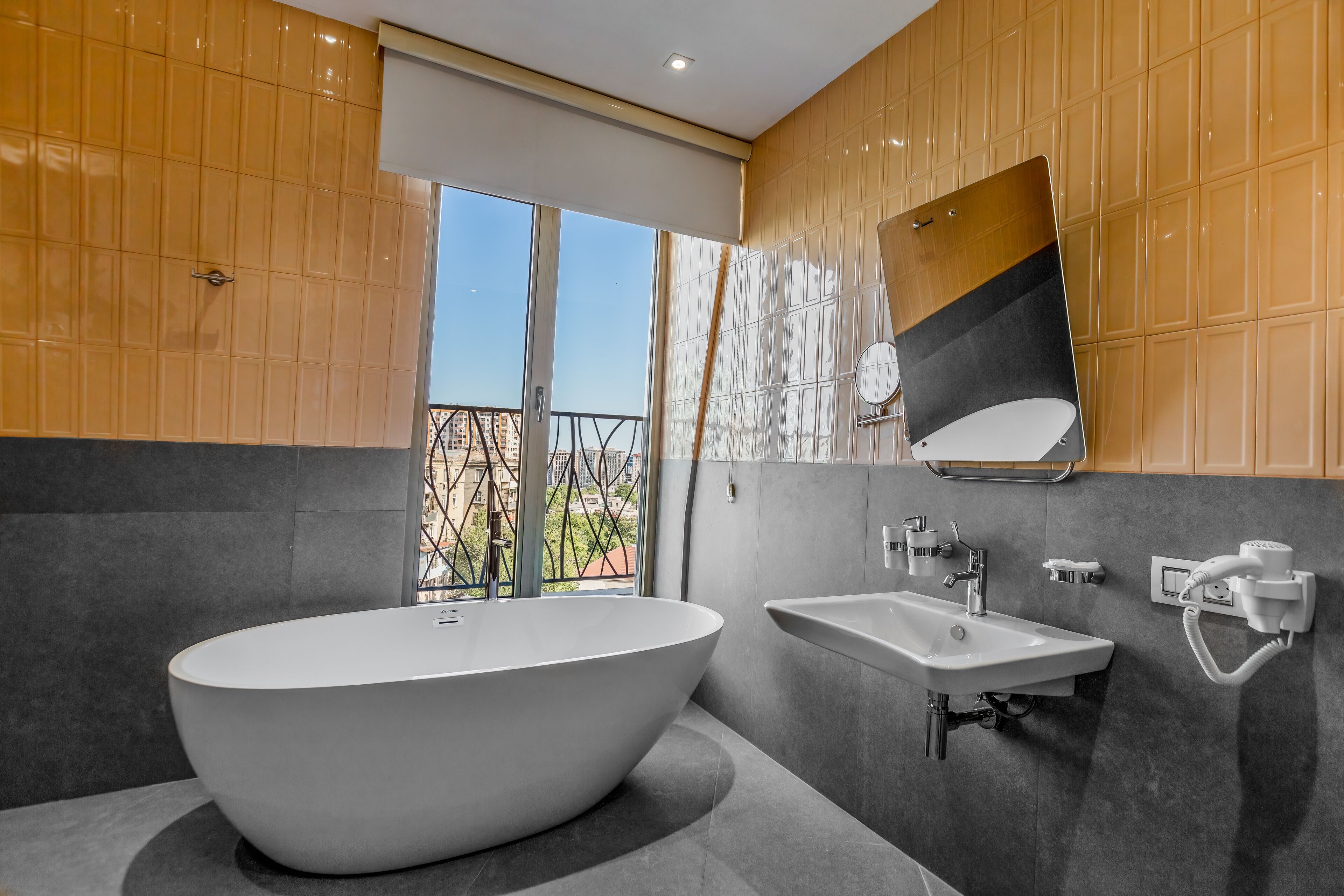 A modern bathroom with a freestanding bathtub, a wall-mounted sink, and a large mirror.
