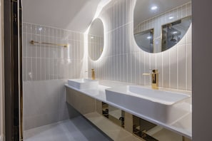 A modern bathroom with two sinks, a large mirror, and a towel rack. - Denbasta heritage Hotel (Gyeongju)