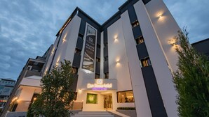 A modern hotel with a prominent entrance, a sign for a grand opening, and a logo indicating a heritage status. - Denbasta heritage Hotel (Gyeongju)