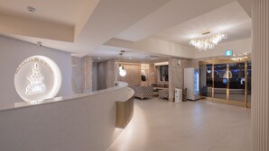 A modern hotel lobby with a reception desk, seating area, and a chandelier. - Denbasta heritage Hotel (Gyeongju)