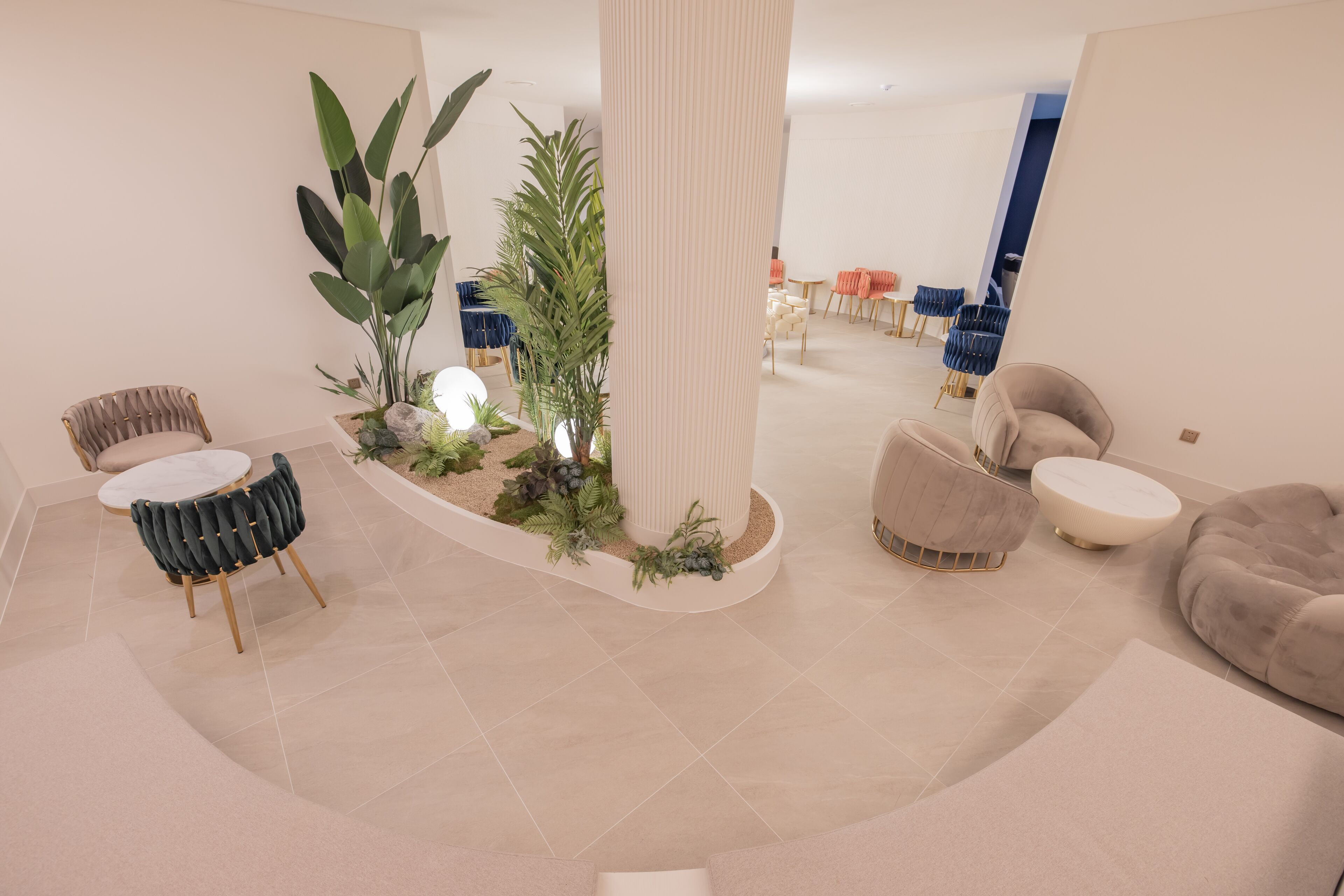 Un intérieur moderne avec une colonne centrale, des espaces de détente et un coin repas.
