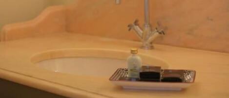 Un baño con lavamanos, espejo y candelabro.