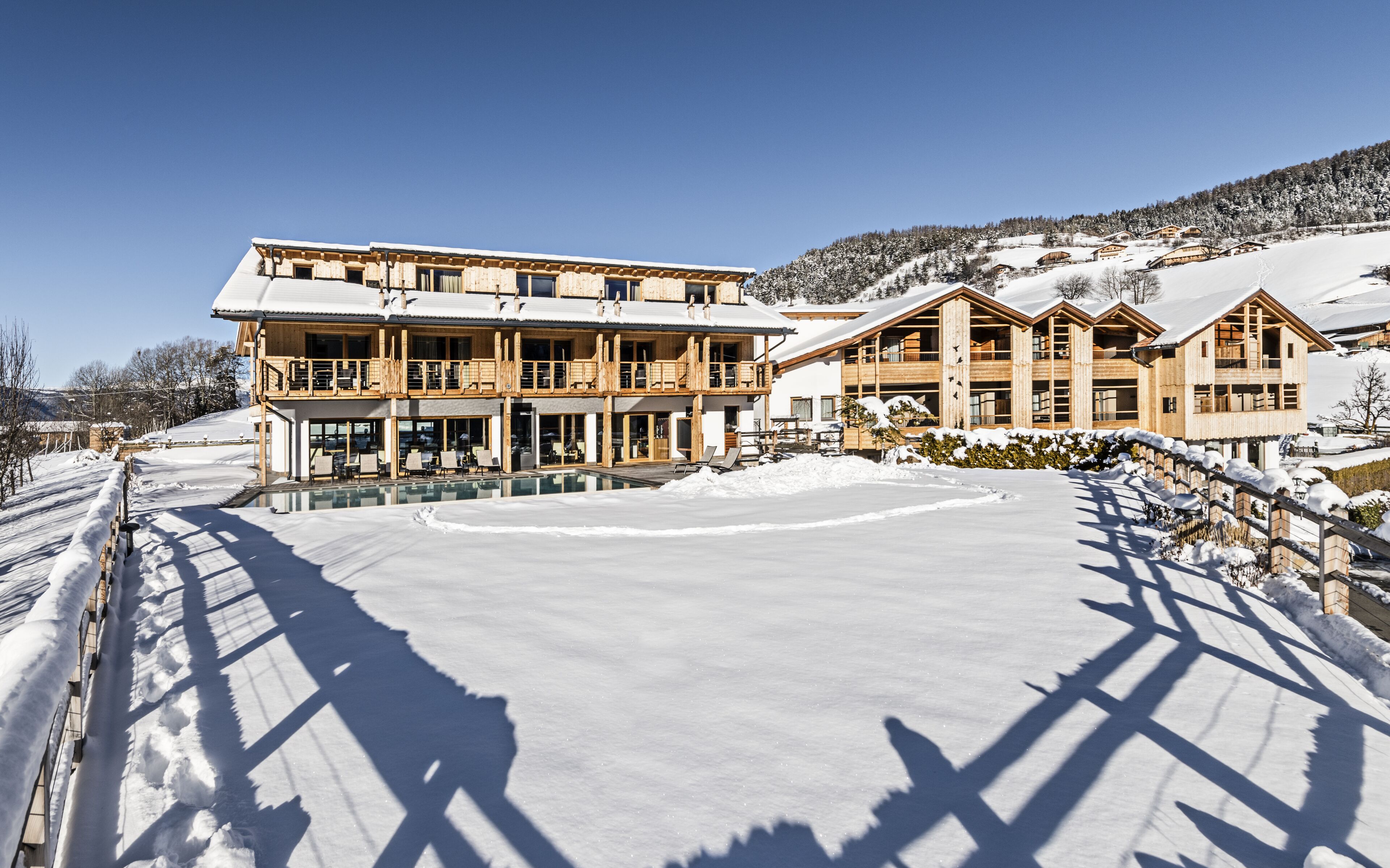 A large wooden building with multiple balconies and a pool area.