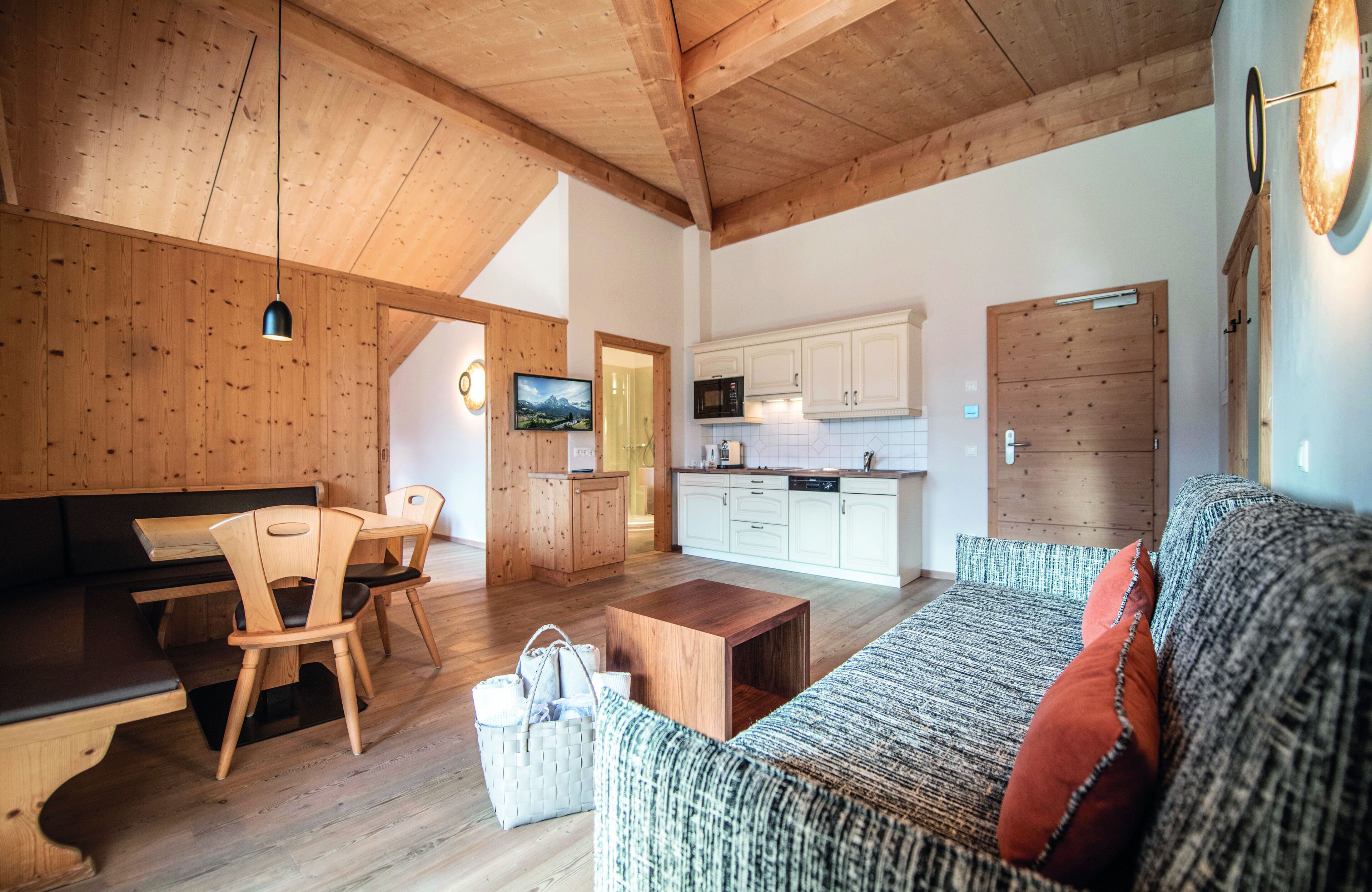 A spacious living area with wooden furniture, a kitchen, and a cozy seating area.