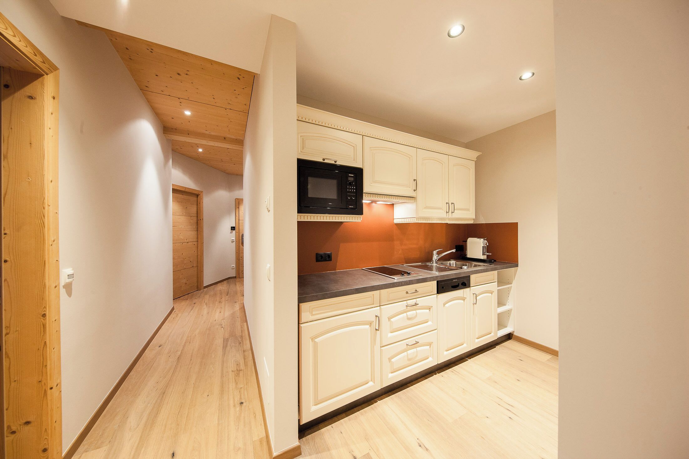Una cocina moderna con armarios blancos, un microondas y un lavabo.