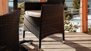 A wooden deck with wicker chairs and a table, overlooking a mountainous landscape. - Sonus Alpis - Adults Only (Castelrotto)