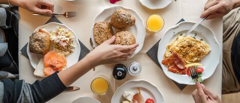 Una mesa con diversos alimentos y bebidas para el desayuno.