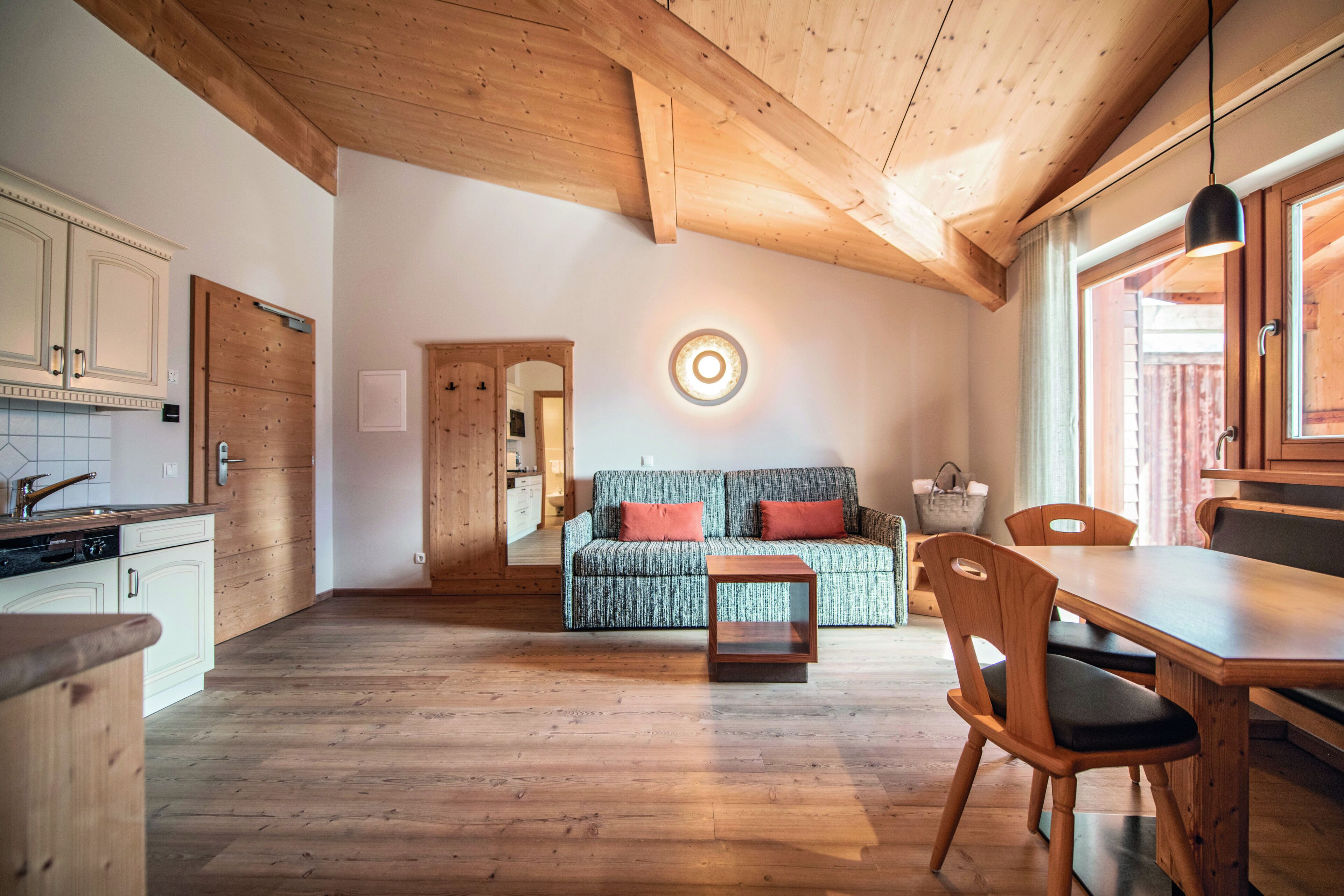 A spacious kitchen with wooden cabinets and a dining area with a wooden table and chairs.