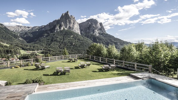 Ein Poolbereich mit Liegestühlen und Bergblick.