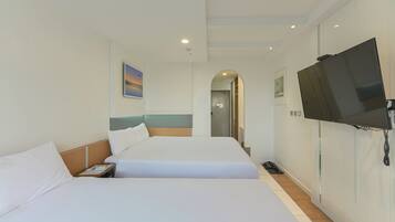 Ein Hotelzimmer mit zwei Betten, einem Fernseher und einem Telefon.