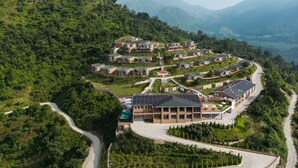 Una zona residencial en una ladera, con varios edificios, caminos y áreas verdes.