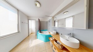 Bathtub, hair dryer, towels, toilet paper