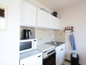 Kitchen features a stove, microwave, and kettle, with ample storage and an oven.