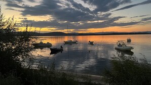 A calm lake with several boats anchored, surrounded by hills and vegetation. - Elesta 2 Bedroom House (Vourvourou)