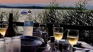 A table set for a meal with a view of the sunset and water in the background. - Elesta 2 Bedroom House (Vourvourou)