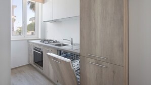 Una cocina moderna con lavavajillas integrado, estufa y lavabo.