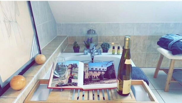 Ett bricka med en vinflaska, ett vinglas och en bok med en bild av en stadsbild.