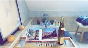 A tray with a wine bottle, a glass, and a book with a cityscape image. - Cozy house with a terrace near the train station (Sélestat)