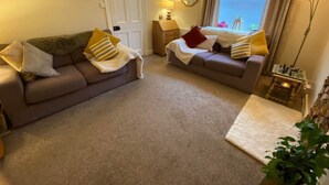 A living room with two sofas, a lamp, a chessboard, and a painting on the wall. - Newburghaprtment/scotland/sleeps 4/firepit/garden (Cupar)