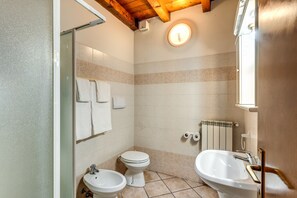 Een douche, een regendouche, een bidet, handdoeken