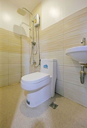 A modern bathroom with a toilet, a shower, and a sink.