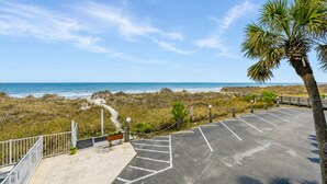A parking lot with a view of the beach and ocean.