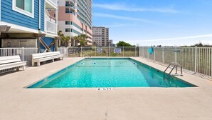 A swimming pool with a lifeguard stand, benches, and a fence. - Oceanfront 2BR • Balcony Views  & Oceanside Pool • Dog Friendly • A Summer Place B8 (North Myrtle Beach)