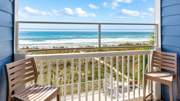 A balcony with a view of the ocean, two wooden chairs, and a railing. - Oceanfront 2BR • Balcony Views  & Oceanside Pool • Dog Friendly • A Summer Place B8 (North Myrtle Beach)