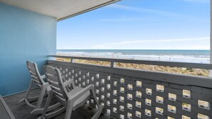 A balcony with a view of the beach, a railing, and two rocking chairs. - Pet-Friendly Oceanfront 2-BR on Top/3rd Floor – Stunning Cherry Grove Beach Views - Blue Mist 302 (North Myrtle Beach)