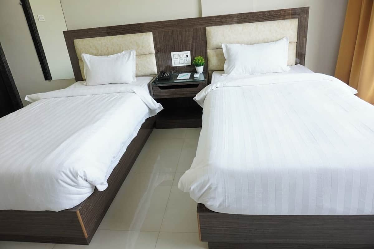 A double bed with a wooden headboard and white bedding.