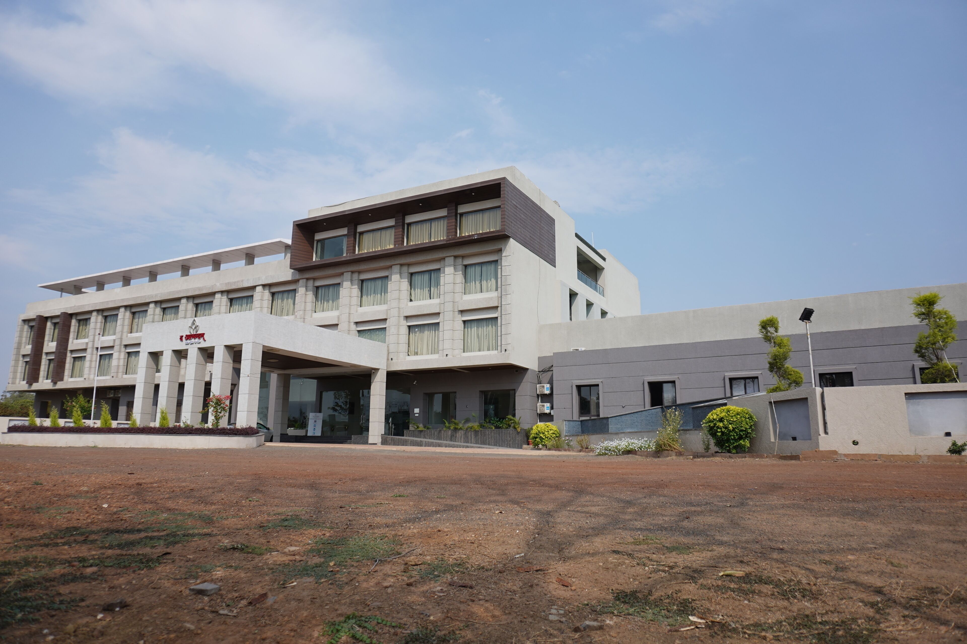 A modern building with a flat roof, large windows, and a covered entrance area.