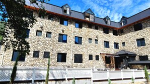 A multi-story stone building with a white fence in front. - Mt Seorak the East Sea and Hot spring (Sokcho)