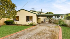 A two-story house with a covered driveway, a fenced yard, and a small garden area. - Views on Bayview - in Cowes (Cowes)