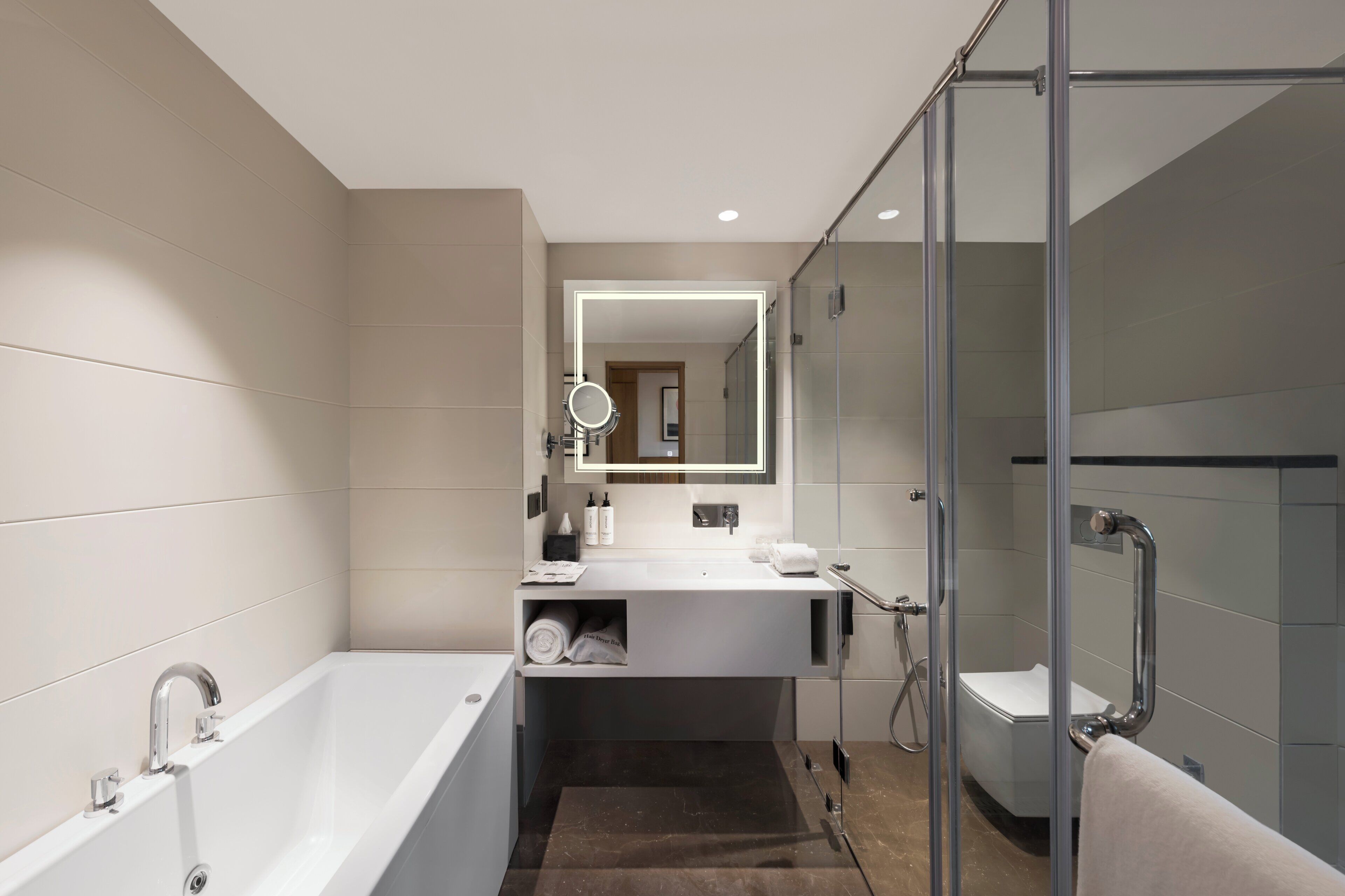 Une salle de bain moderne avec une baignoire, une cabine de douche en verre et un meuble-lavabo avec un miroir.