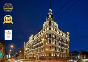 A historic building with ornate architecture, large windows, and a prominent tower. - aparthotel Amella (Riga)