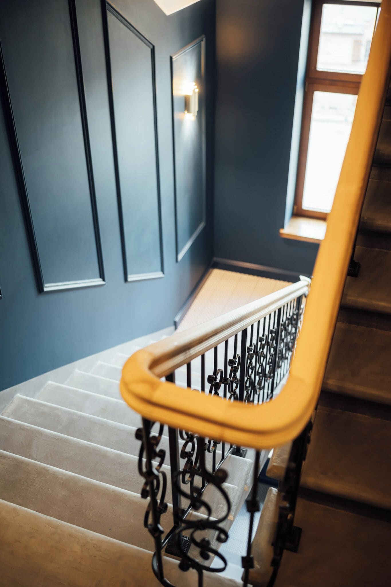 A staircase with a metal railing and a wooden handrail.