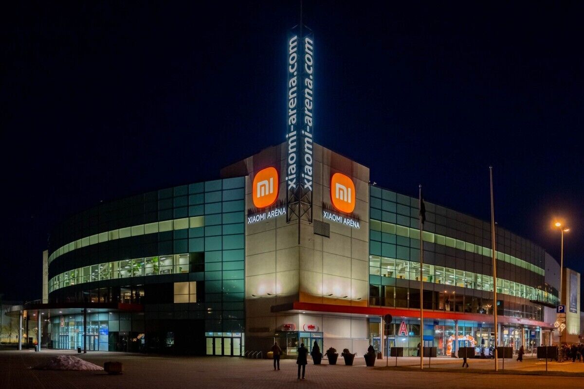 Een modern gebouw met een golvende gevel, verlichte signage en een opvallend entreegebied.