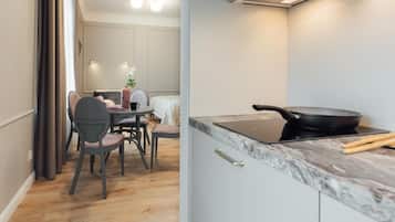 A modern kitchen with a marble countertop, a black frying pan, and a laptop.