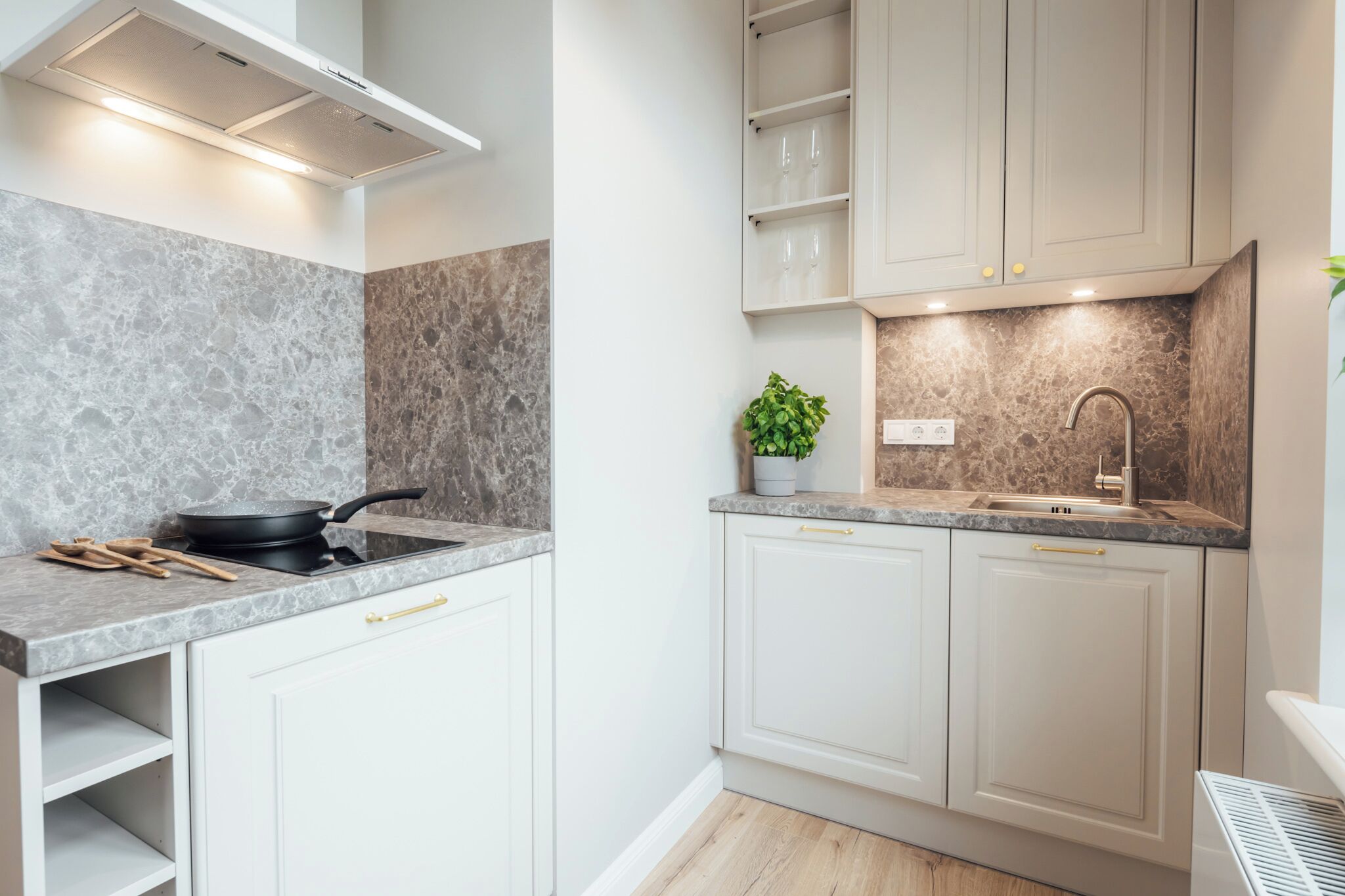 A modern kitchen with white cabinets, a granite countertop, a stove, and a sink.
