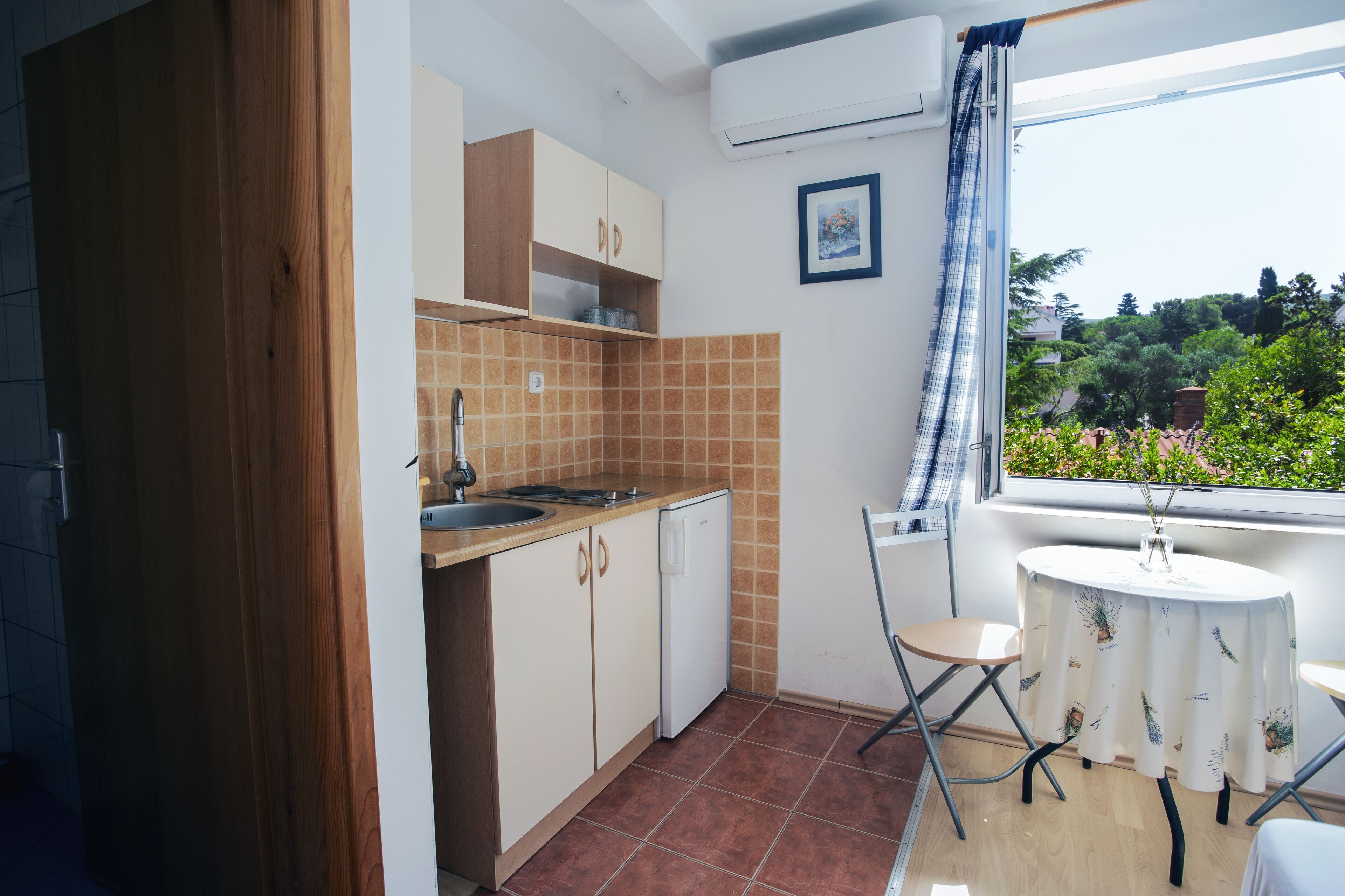 A compact kitchen with a sink, cabinets, and a small dining table.