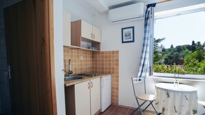 A compact kitchen with a sink, cabinets, and a small dining table.