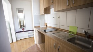 Una cocina moderna con armarios de madera, un lavamanos de acero inoxidable y un horno empotrado.