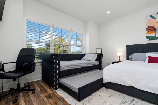 Een slaapkamer met een stapelbed, een bureau en een stoel.