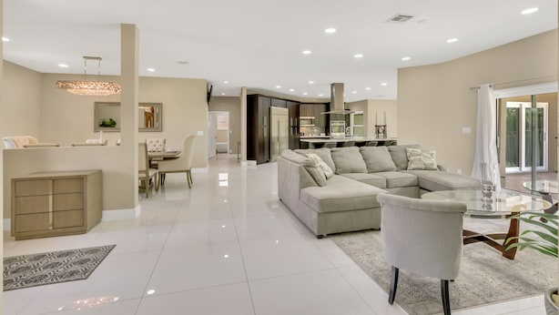 A spacious living area with a large sectional sofa, a dining table, and a kitchen in the background. - Plantation Point: Family Friendly Neighborhood (Plantation)