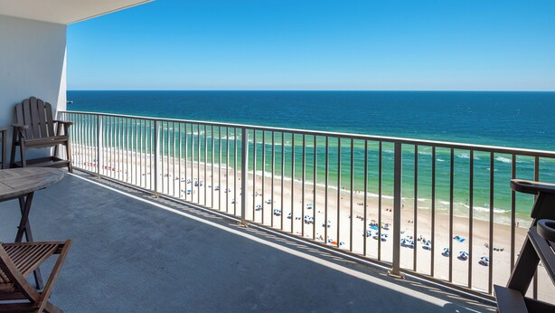 Ein Balkon mit Blick auf Strand und Meer.