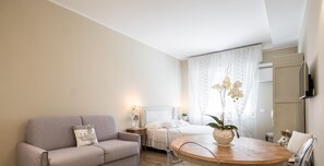 A modern bedroom with a bed, bedside table, lamp, and a window with curtains.