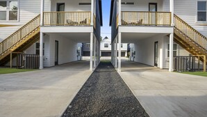 Un bâtiment moderne à deux étages, doté d’une cour intérieure, de balustrades en bois et d’un chemin bordé de gravier.